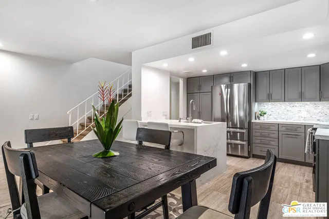 a kitchen with a table chairs and a refrigerator