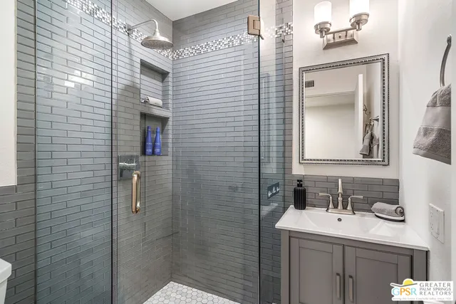 a bathroom with a sink vanity granite and a mirror