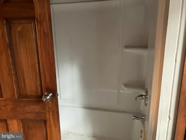 a bathroom with a glass door shower and a tub