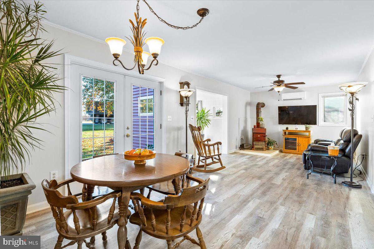 6936 Linganore Road Frederick, MD 21701 - Photo 12 of 33 a view of a dining room with furniture a chandelier and wooden floor