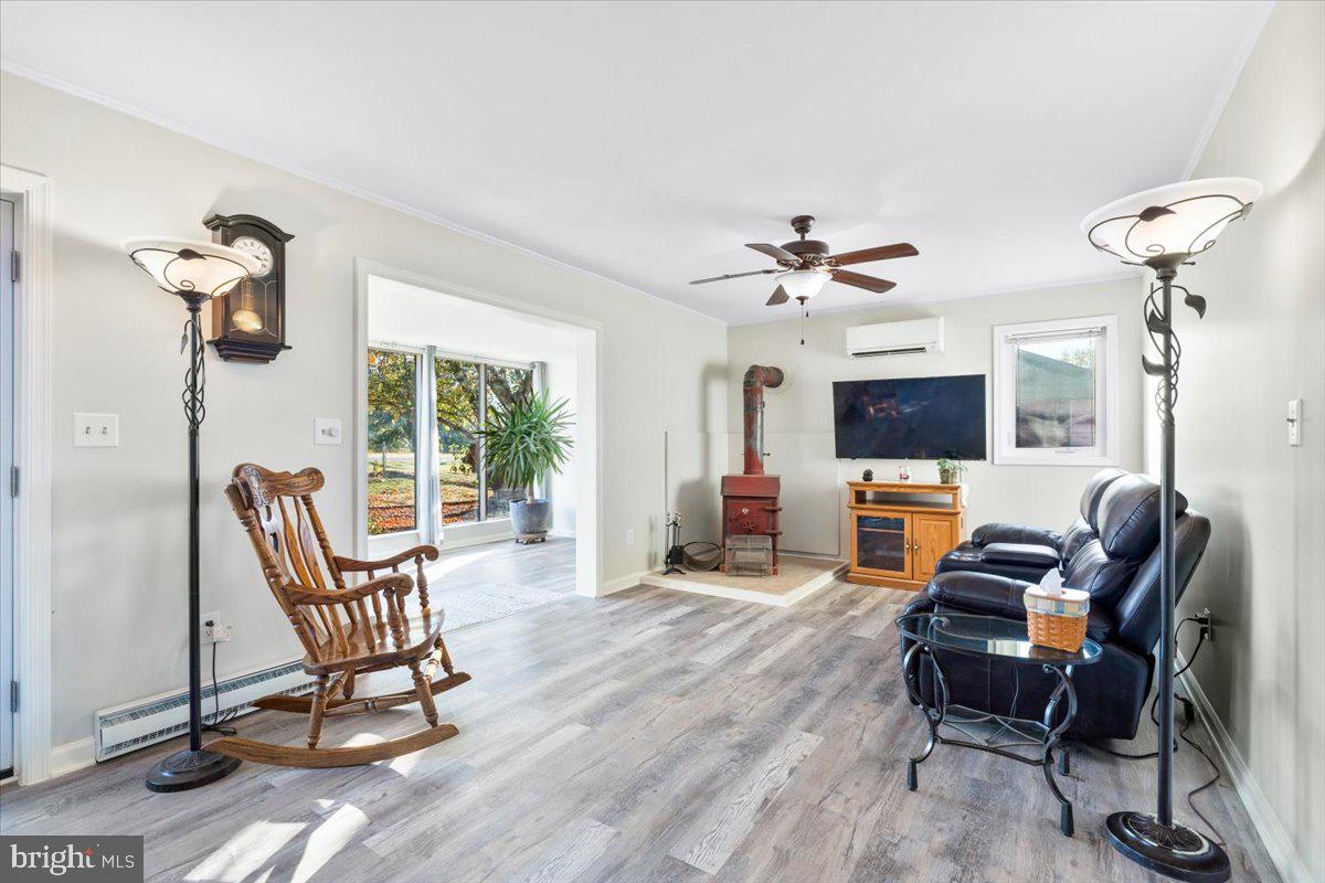 6936 Linganore Road Frederick, MD 21701 - Photo 6 of 33 a living room with furniture a flat screen tv and a floor to ceiling window