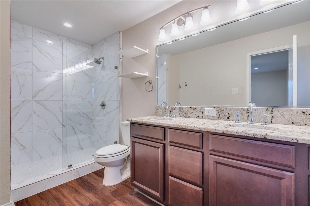 267 Carolyns Way Buda, TX 78610 - Photo 17 of 31 a bathroom with a granite countertop sink toilet and shower