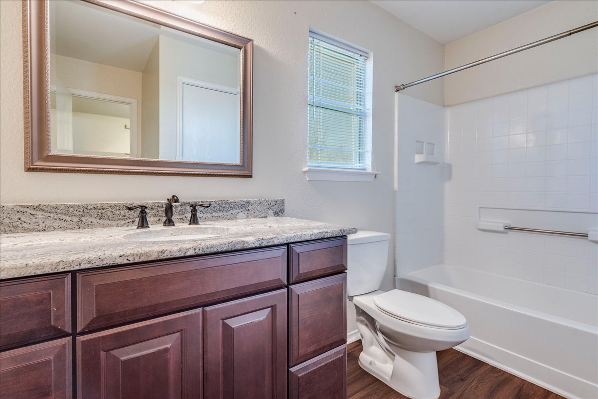 267 Carolyns Way Buda, TX 78610 - Photo 24 of 31 a bathroom with a granite countertop toilet sink and mirror