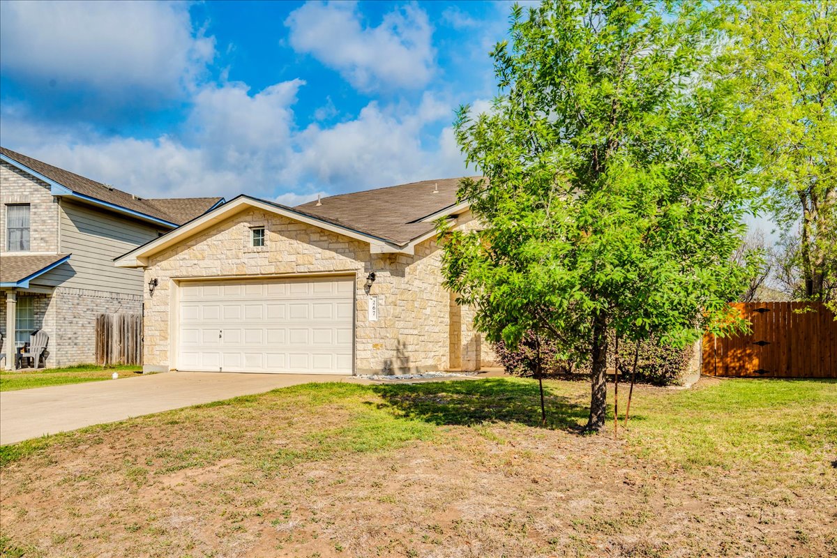 267 Carolyns Way Buda, TX 78610 - Photo 3 of 31 a front view of a house with a yard and garage