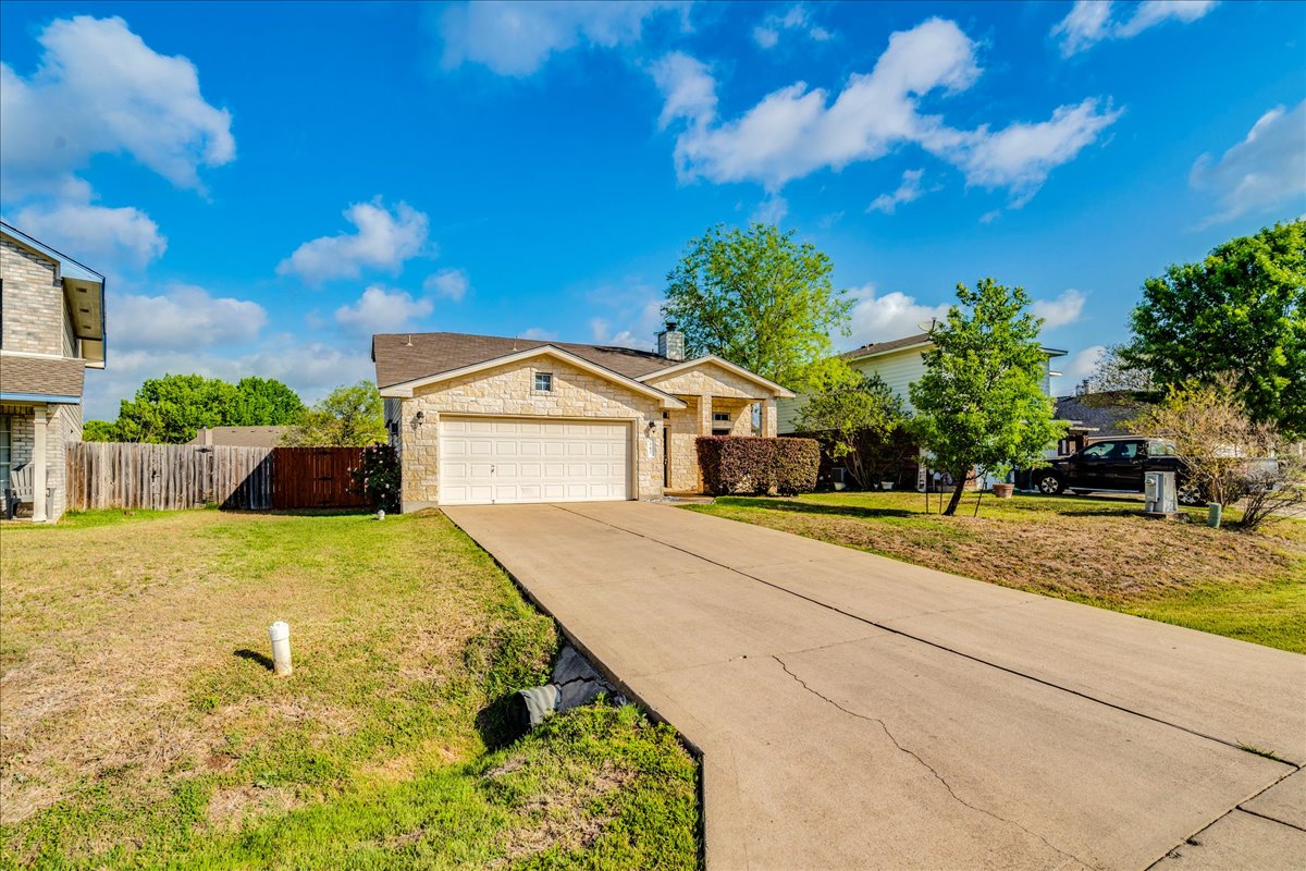 267 Carolyns Way Buda, TX 78610 - Photo 5 of 31 a front view of a house with a yard and garage