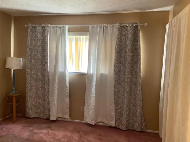 a bedroom with a bed and a flat tv screen on dresser
