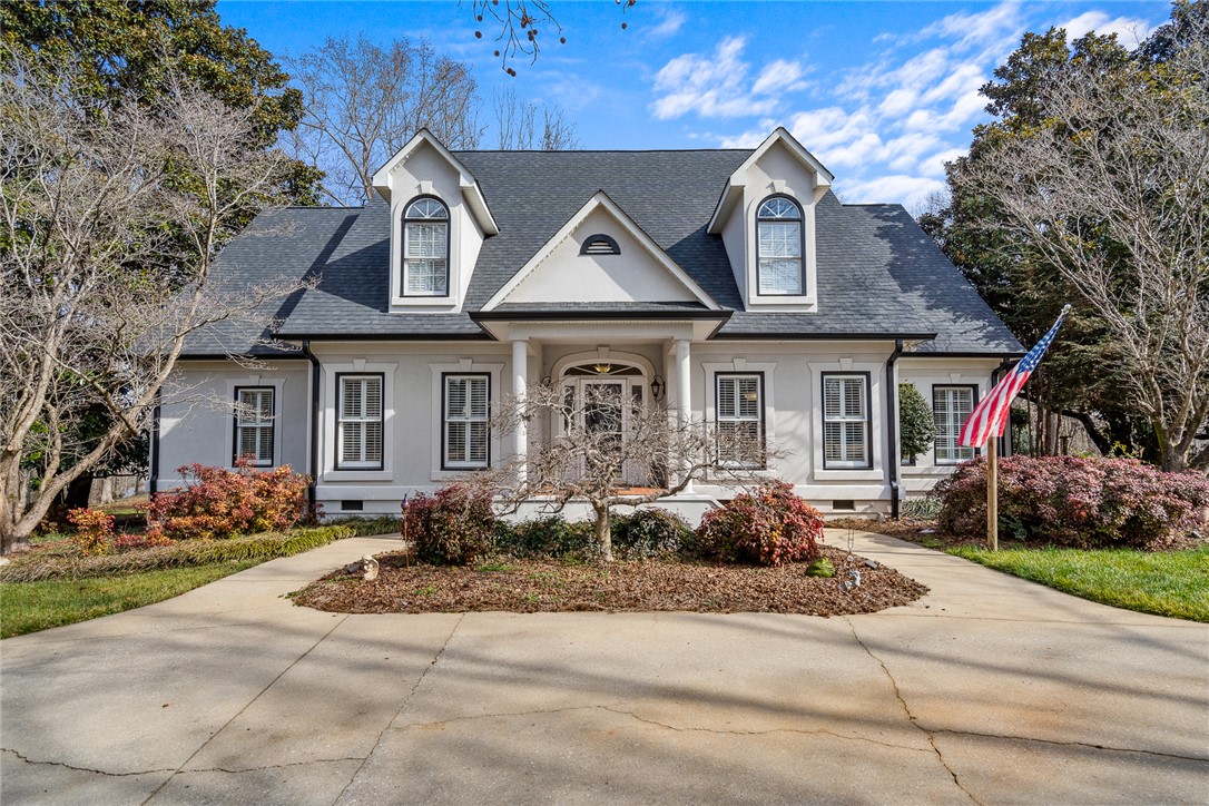 This classic facade features an inviting entryway and dormer windows, exuding timeless appeal.