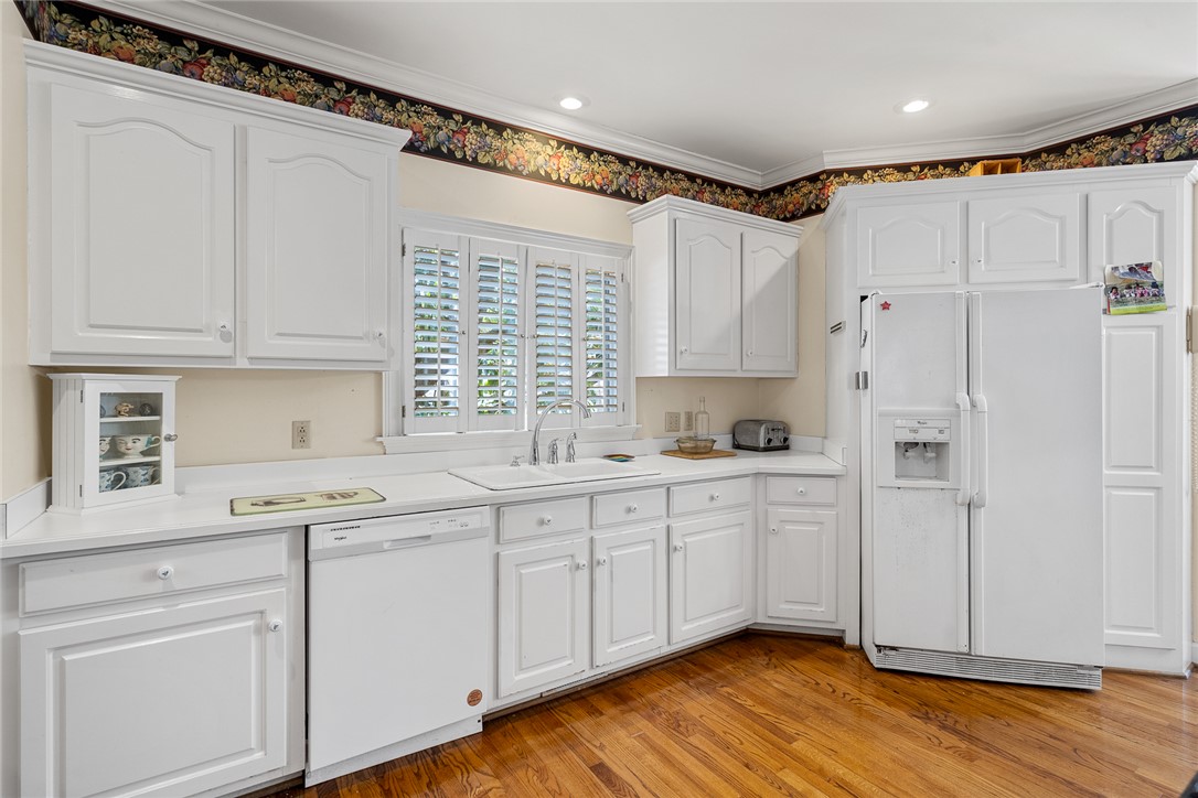 4011 Brackenberry Drive Anderson, SC 29621 - Photo 14 of 35 This bright kitchen features classic white cabinetry and rich hardwood flooring, creating a welcoming culinary space.