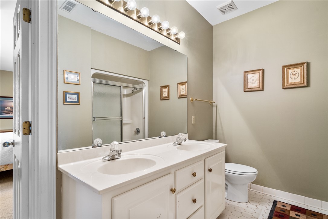 4011 Brackenberry Drive Anderson, SC 29621 - Photo 27 of 35 This bright bathroom features a spacious vanity with dual sinks, a shower, and sleek tile flooring.