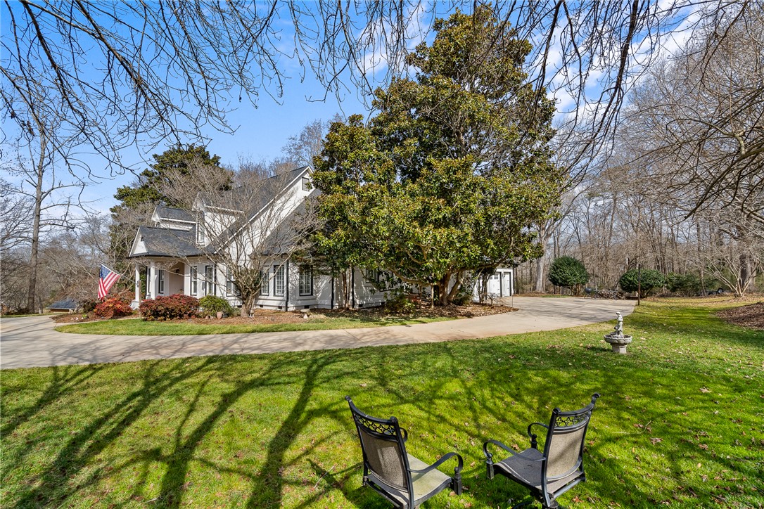 4011 Brackenberry Drive Anderson, SC 29621 - Photo 35 of 35 This charming home features a circular driveway, surrounded by mature trees, and a spacious green lawn.