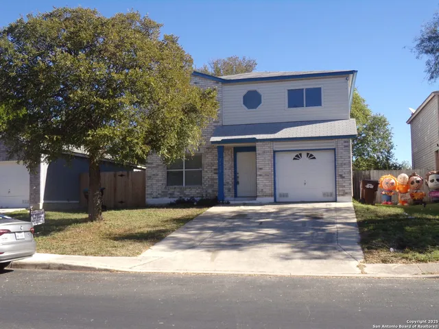 a front view of a house with a yard and a garage