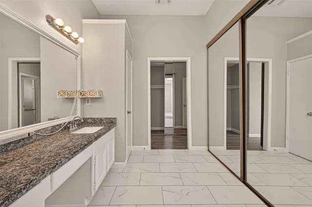 a bathroom with a granite countertop sink a mirror and a shower