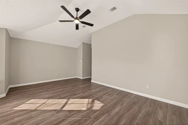 a view of a big room with wooden floor and a ceiling fan
