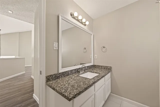 a bathroom with a granite countertop sink and a mirror
