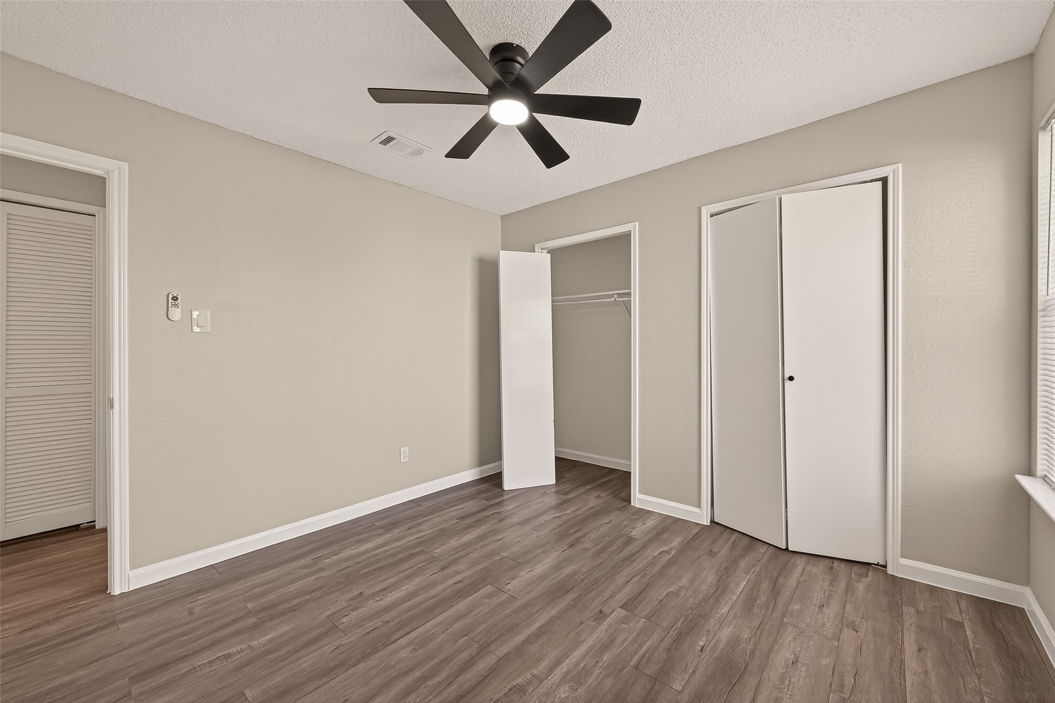 7622 Poitiers Drive Houston, TX 77071 - Photo 34 of 37 an empty room with wooden floor ceiling fan and windows