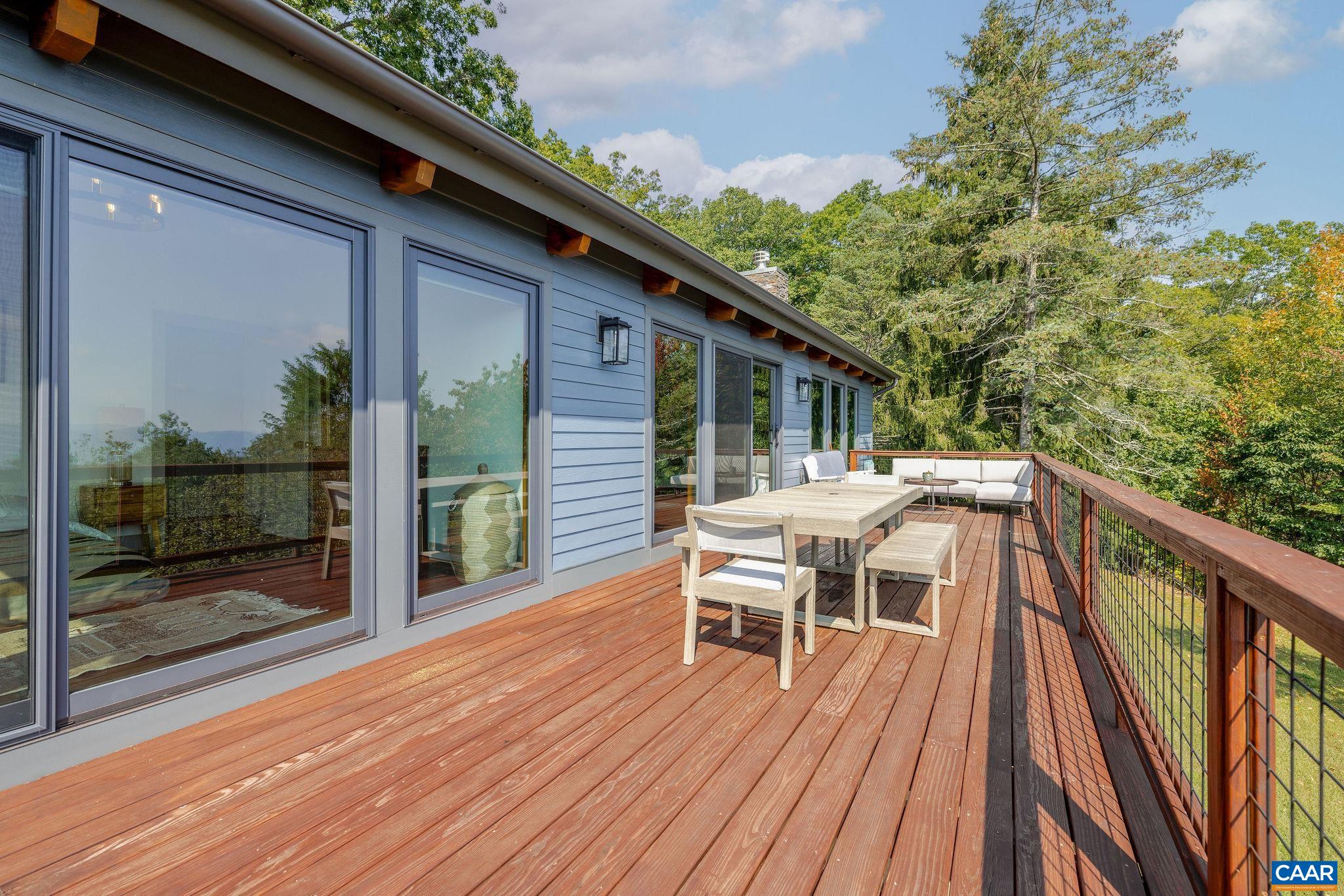 6288 Bryant Hollow Road Elkton, VA 22827 - Photo 9 of 54 a view of a patio with table and chairs with wooden floor and fence