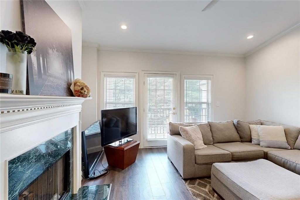 3275 Lenox Road Northeast, Unit 413 Atlanta, GA 30324 - Photo 10 of 52 a living room with furniture a flat screen tv and a fireplace