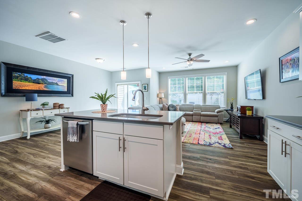 1007 Longitude Drive Durham, NC 27713 - Photo 12 of 35 a kitchen with kitchen island granite countertop a sink cabinets and stainless steel appliances