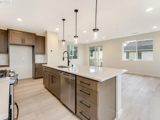 a large kitchen with kitchen island a sink stainless steel appliances and a counter top space