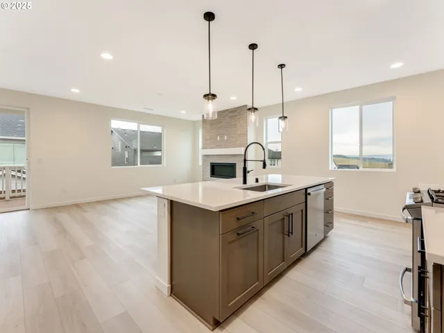 a kitchen with a sink stove and wooden floor