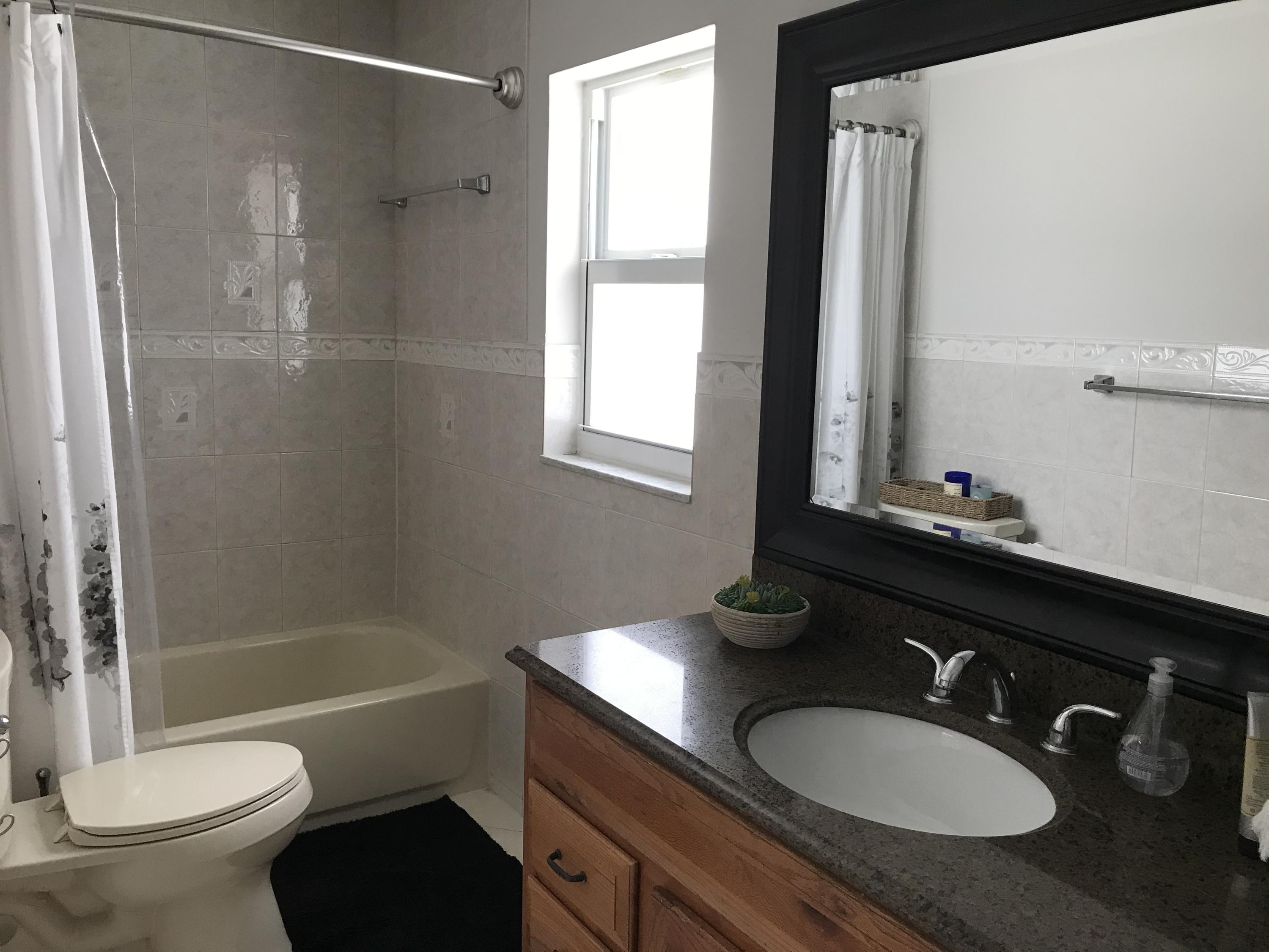 22307 Doran Avenue Boca Raton, FL 33428 - Photo 9 of 25 a bathroom with a granite countertop sink toilet a mirror and shower