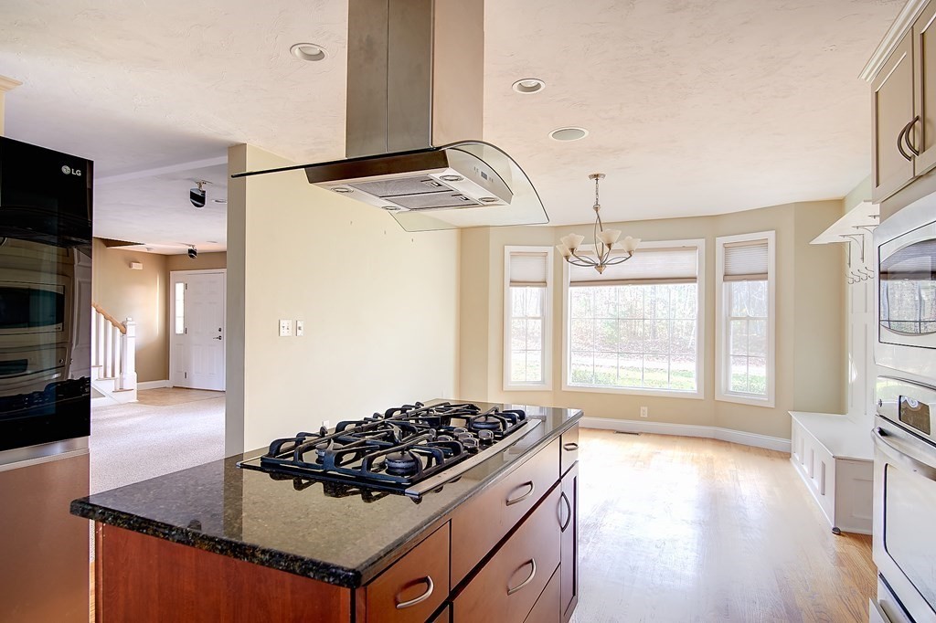 4 Alyssa Drive Townsend, MA 01469 - Photo 10 of 35 a kitchen with granite countertop a stove and a wooden floor