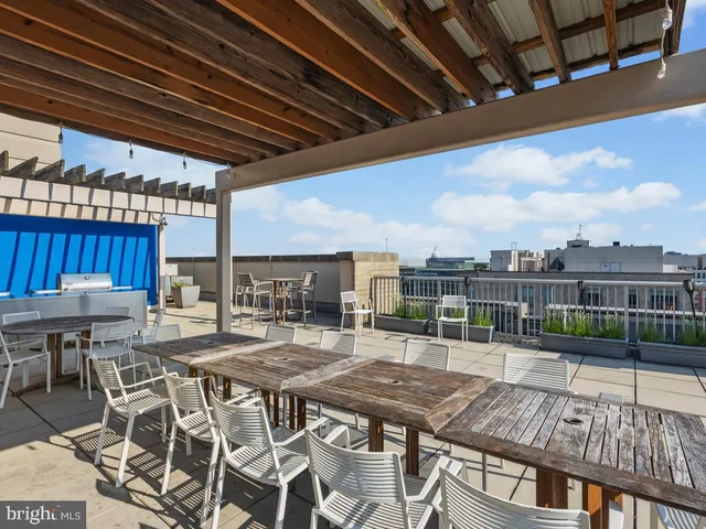 a view of a roof deck with table and chairs with wooden floor and fence