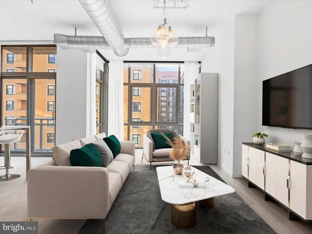 a living room with furniture a flat screen tv and a chandelier