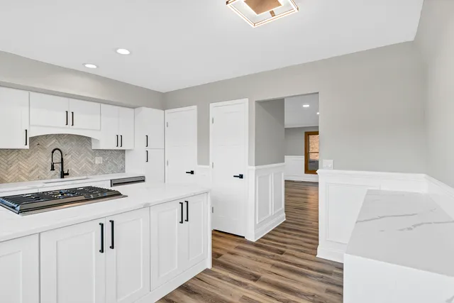 a kitchen with white cabinets and sink