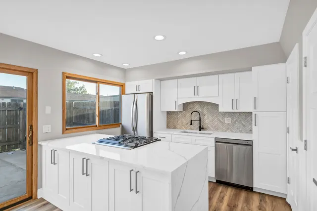 a kitchen with stainless steel appliances granite countertop a sink stove and refrigerator