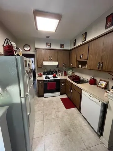 a kitchen with stainless steel appliances granite countertop a sink refrigerator and cabinets