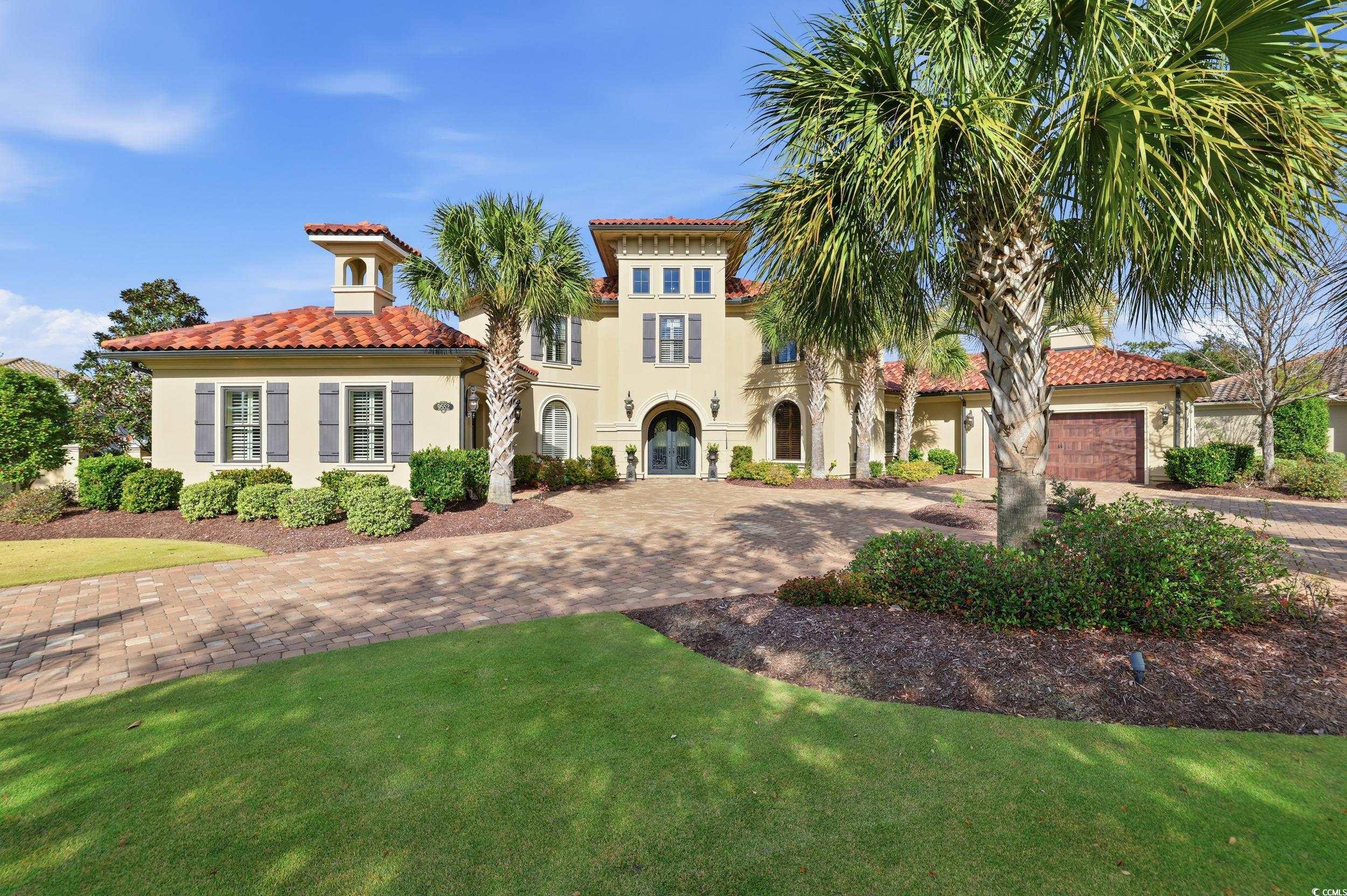 Mediterranean / spanish-style home featuring stucco siding, decorative driveway, a front yard, and a tile roof