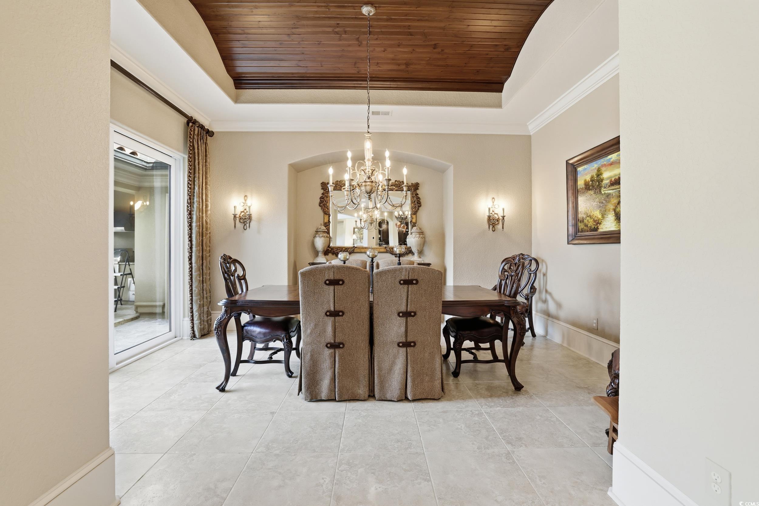 9552 Lugano Court Myrtle Beach, SC 29579 - Photo 13 of 40 Dining room featuring wood ceiling, a chandelier, ornamental molding, a raised ceiling, and light tile patterned floors