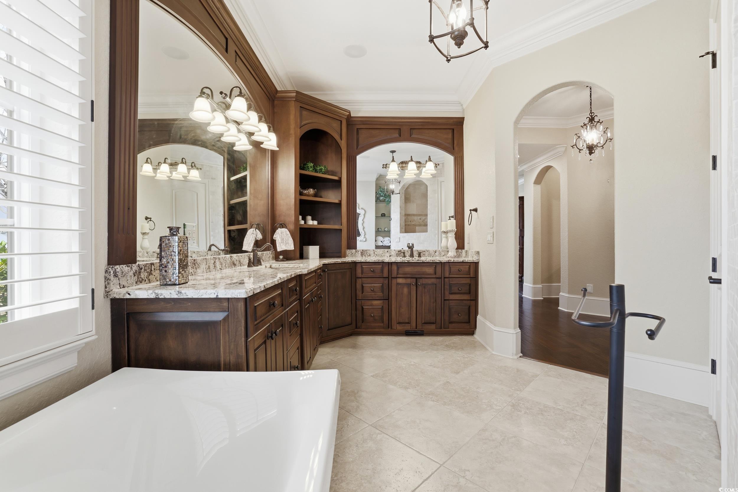 9552 Lugano Court Myrtle Beach, SC 29579 - Photo 23 of 40 Full bath with a chandelier, two vanities, crown molding, a bathtub, and light tile patterned floors