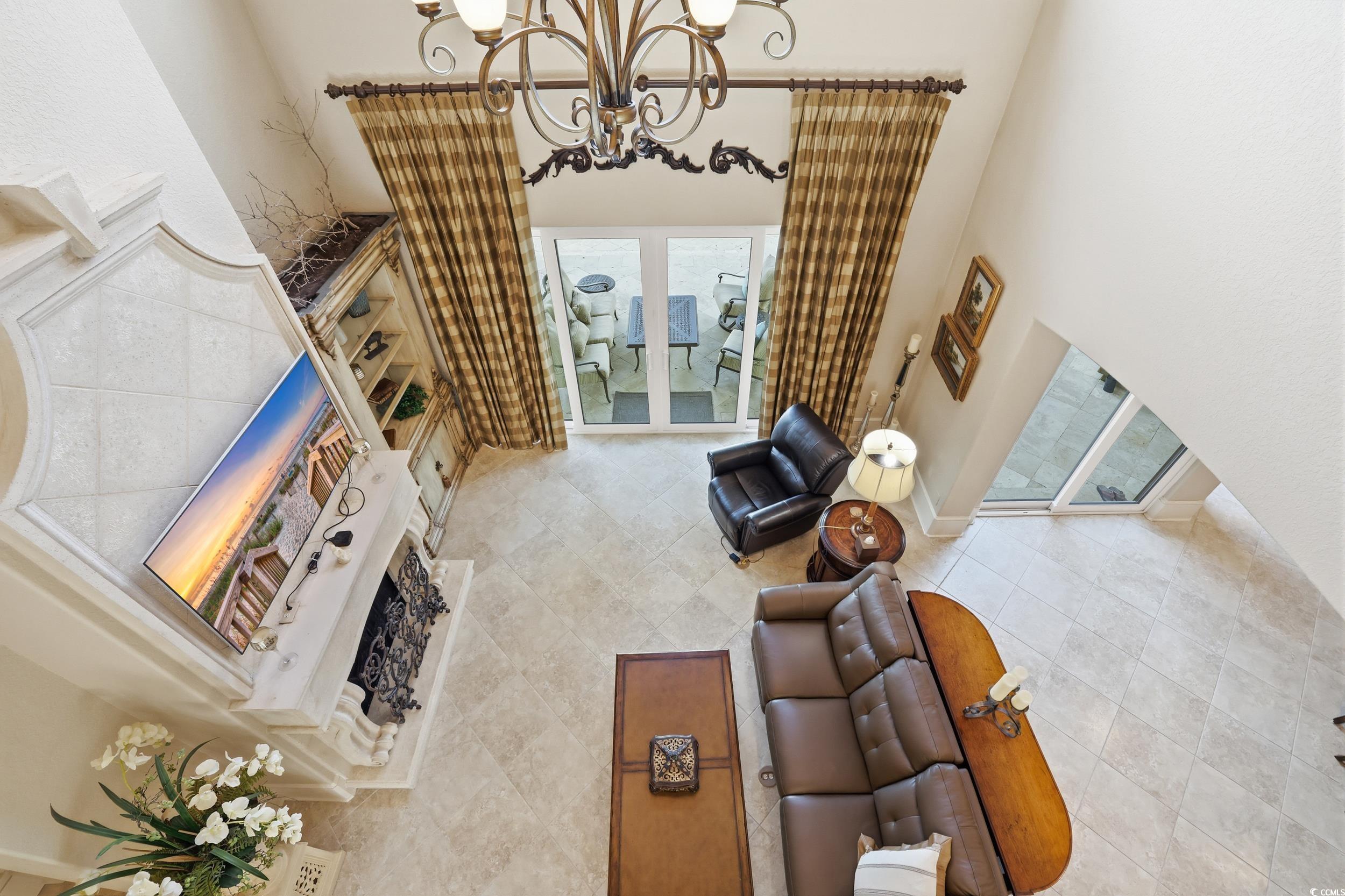 9552 Lugano Court Myrtle Beach, SC 29579 - Photo 34 of 40 Tiled living room featuring a towering ceiling, a chandelier, and french doors