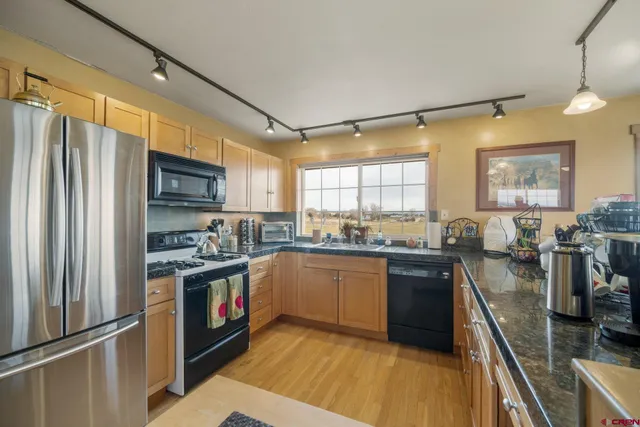 a kitchen with stainless steel appliances granite countertop sink stove top oven and cabinets