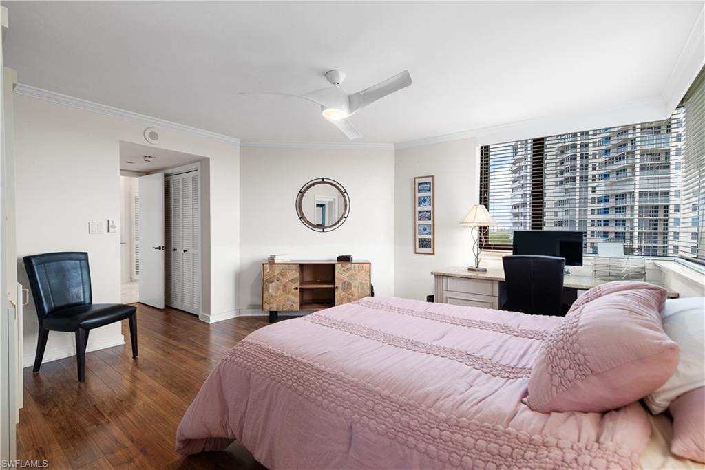 5555 Heron Point Drive, Unit 1202 Naples, FL 34108 - Photo 25 of 36 a bedroom with a bed a mirror and a large window