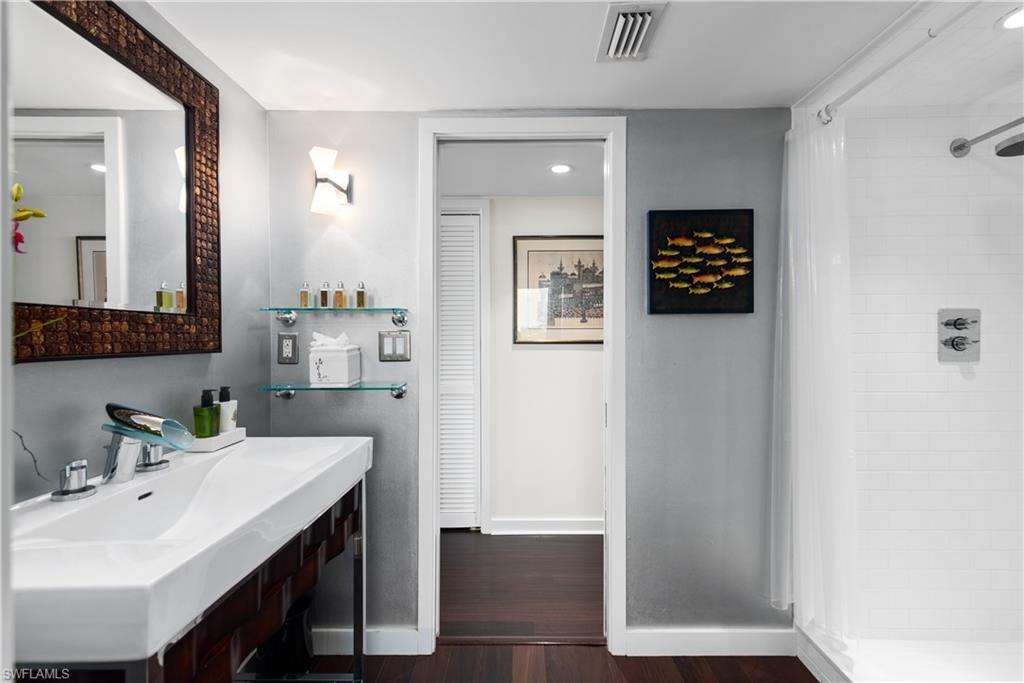 5555 Heron Point Drive, Unit 1202 Naples, FL 34108 - Photo 27 of 36 a bathroom with a sink a mirror and a shower