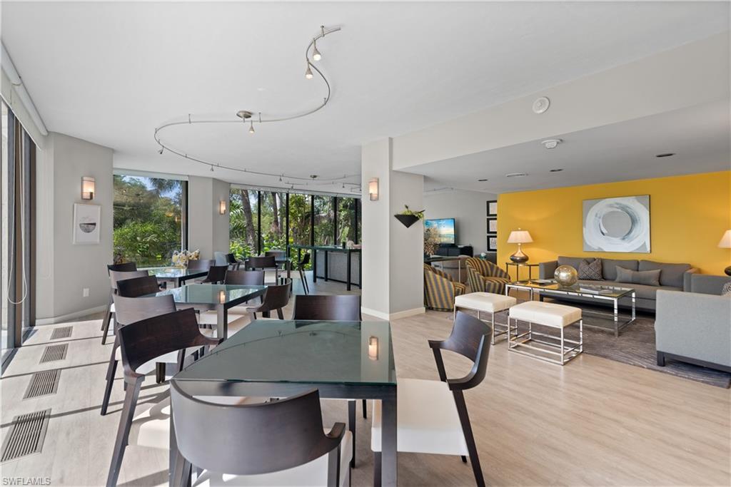 5555 Heron Point Drive, Unit 1202 Naples, FL 34108 - Photo 28 of 36 a view of a dining room with furniture window and wooden floor