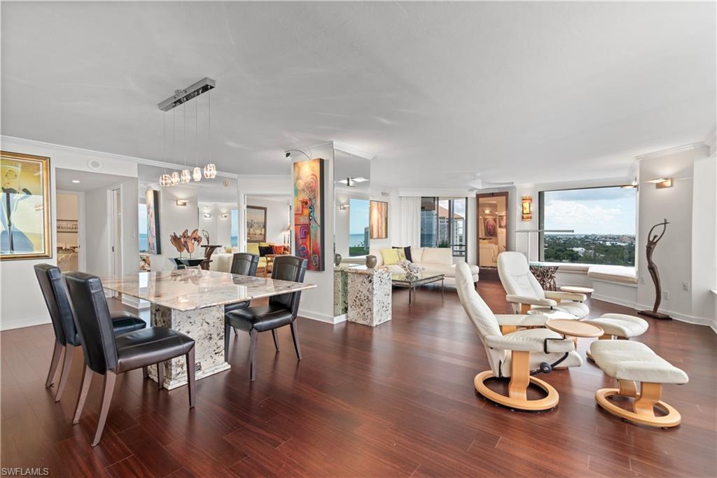 5555 Heron Point Drive, Unit 1202 Naples, FL 34108 - Photo 3 of 36 a living room with furniture floor to ceiling window and wooden floor