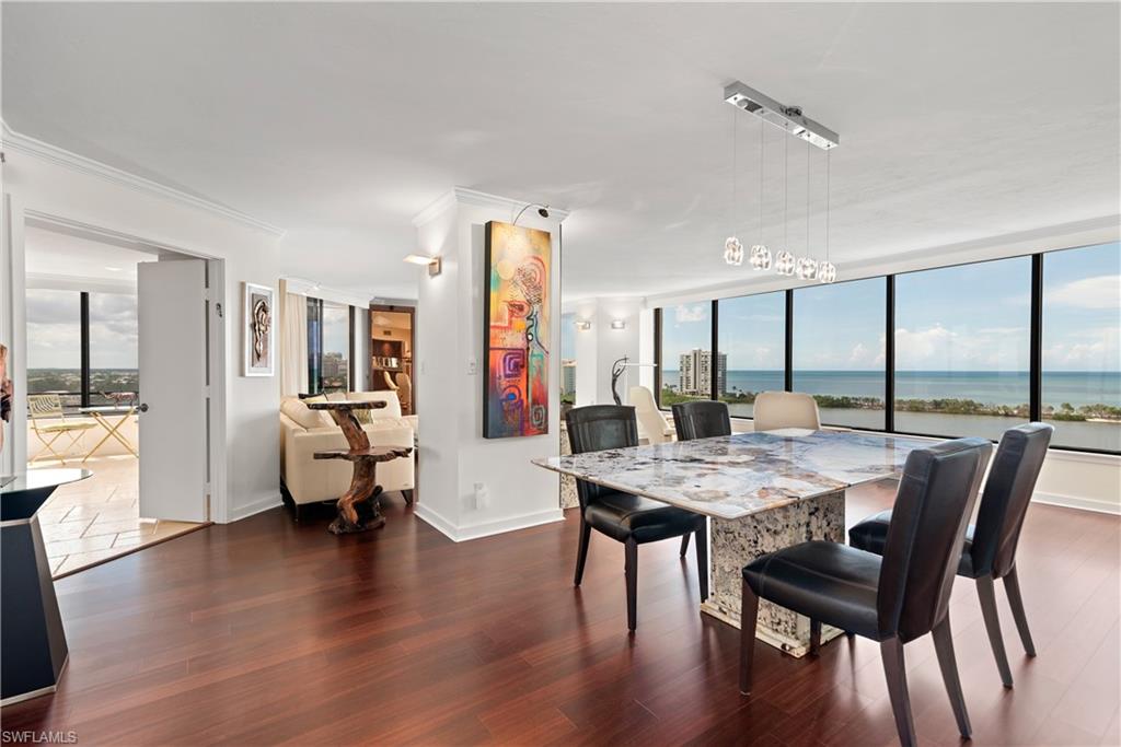 5555 Heron Point Drive, Unit 1202 Naples, FL 34108 - Photo 5 of 36 a view of a dining room with furniture and wooden floor