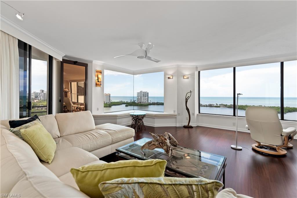 5555 Heron Point Drive, Unit 1202 Naples, FL 34108 - Photo 6 of 36 a living room with furniture and floor to ceiling windows