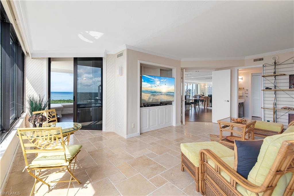 5555 Heron Point Drive, Unit 1202 Naples, FL 34108 - Photo 10 of 36 a living room with furniture and a table