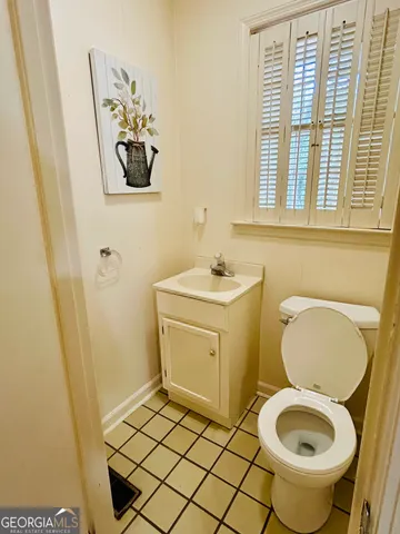 a view of kitchen with refrigerator and white cabinets