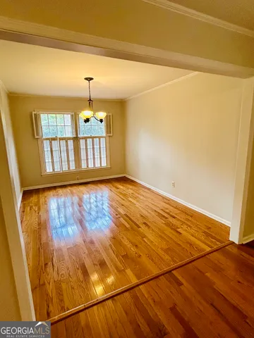 en empty room with window and wooden floor