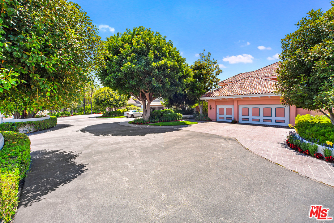 2113 Stoney Hill Road Los Angeles, CA 90049 - Photo 1 of 48 a front view of a house with a yard and a garage