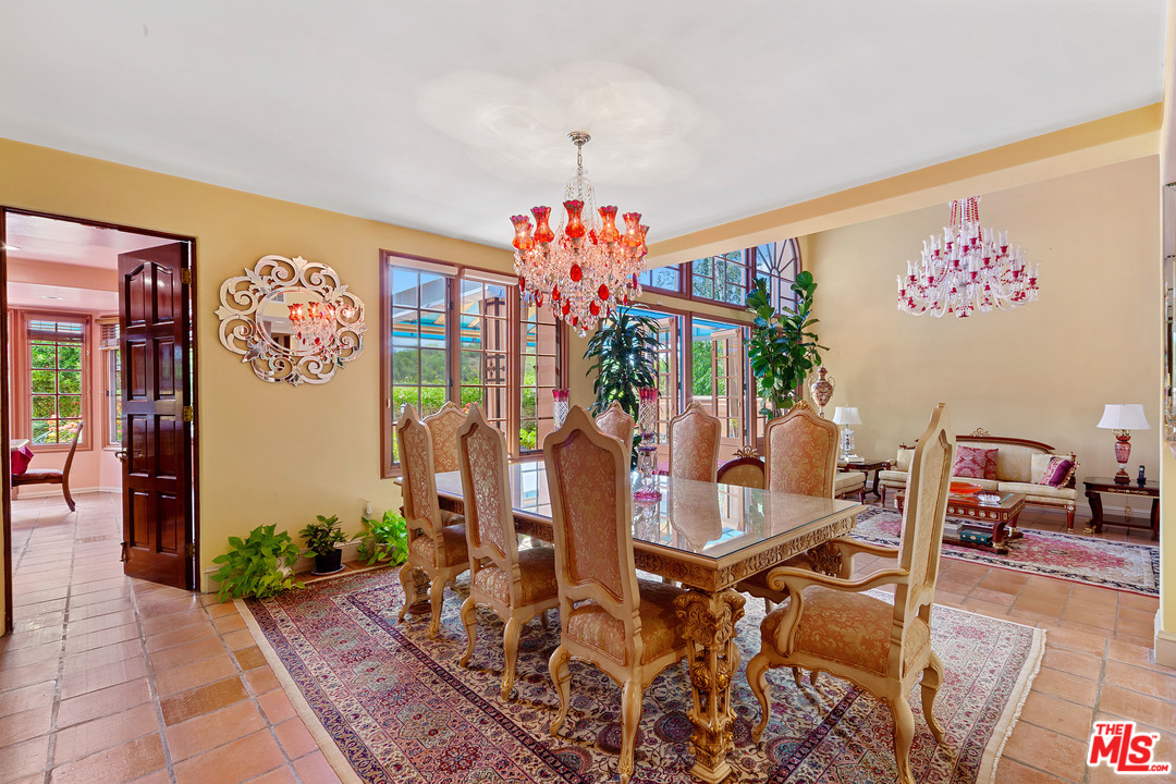 2113 Stoney Hill Road Los Angeles, CA 90049 - Photo 23 of 48 a view of a dining room with furniture wooden floor and a chandelier