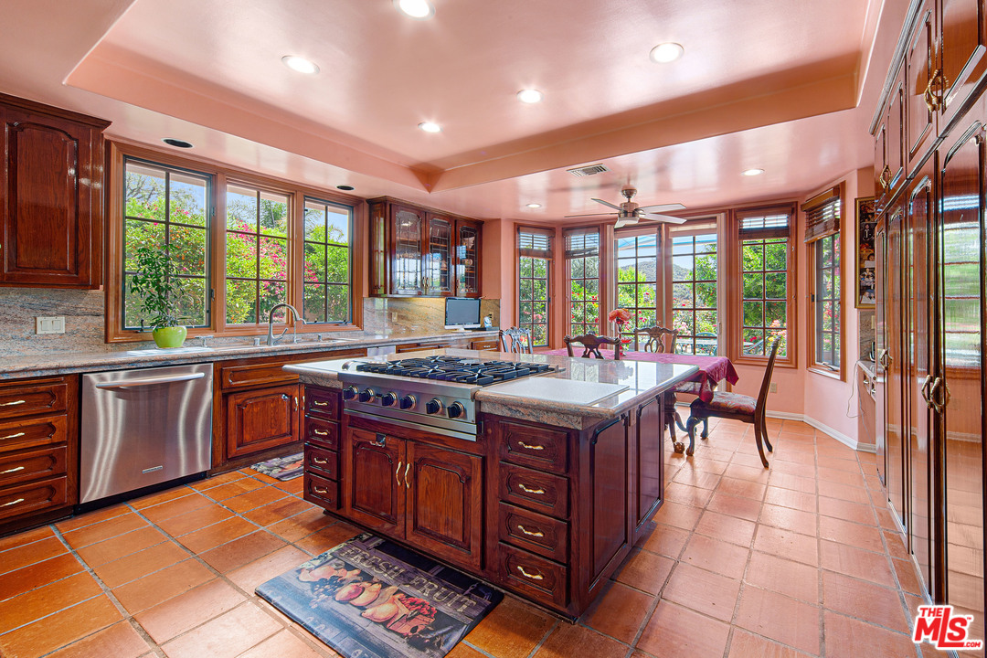 2113 Stoney Hill Road Los Angeles, CA 90049 - Photo 27 of 48 a kitchen with stainless steel appliances granite countertop a stove a sink and a microwave