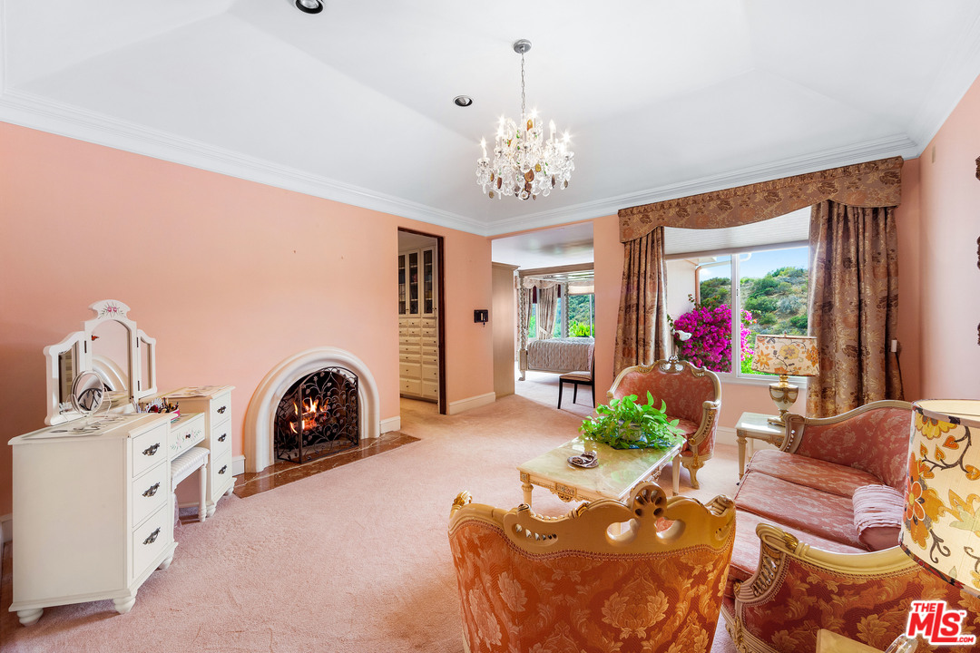 2113 Stoney Hill Road Los Angeles, CA 90049 - Photo 29 of 48 a living room with furniture a fireplace and a chandelier