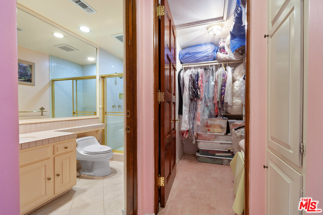 2113 Stoney Hill Road Los Angeles, CA 90049 - Photo 43 of 48 a bathroom with a toilet a sink and a large mirror